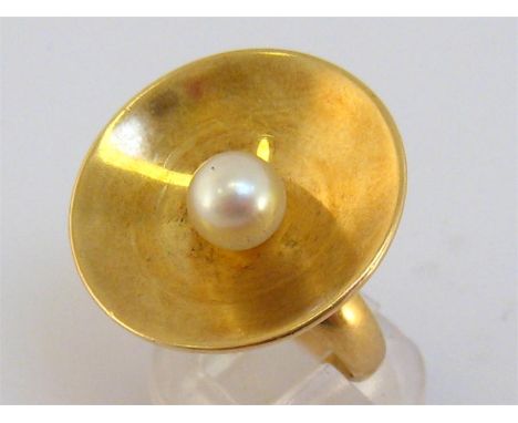 A 1960s 18 carat gold and cultured pearl ring by Georg Jensen, design by Nanna Ditzel, the concave disc set to the centre wit