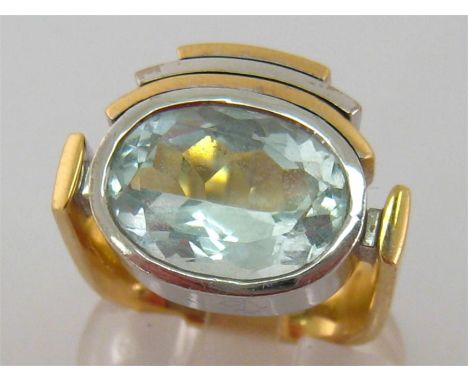 A yellow metal (tests 14 carat) aquamarine dress ring, the oval stone 14.7 x 10.4 x 7 (deep) mm rub over set within an Art De