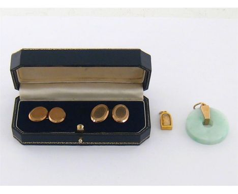 A small gold Buddha charm, with glazed panel to the front, 15mm long, 1.9gms, together with a jade bi, 33mm diameter, and a p