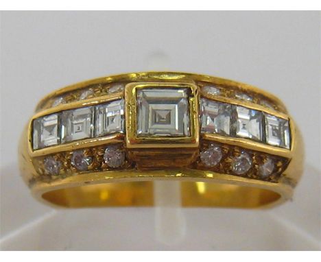 An 18 carat gold and diamond ring, the central square cut stone 3.4 x 3.4mm, to calibre and brilliant cut shoulders, the shan