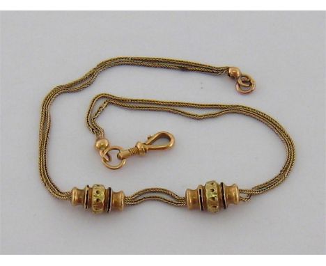 A French 18 carat gold watch chain, weighted with a pair of two-colour gold and enamel baluster beads, 30m long, 10.7gms