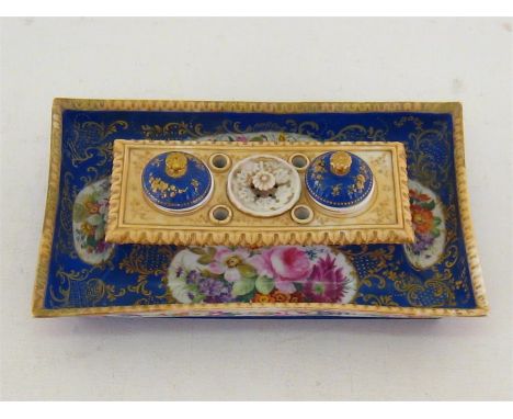 A 19th. century continental ceramic rectangular inkstand, the central ivory coloured upstand with two covered wells and pounc