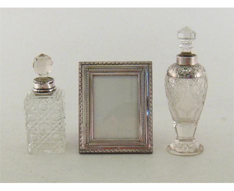 An Edwardian silver-mounted cut glass scent bottle, Birmingham, 1907, ovoid with chased mount and detachable stopper; another