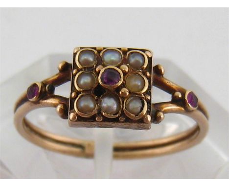 A mid 19th century gold, seed pearl and ruby ring, the square bezel 7mm, to ruby set bifurcated shoulders, the shank marked ‘