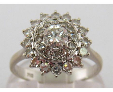 An 18 carat white gold and diamond cluster ring, the central brilliant 0.38 carat in a two tiered surround, the total diamond