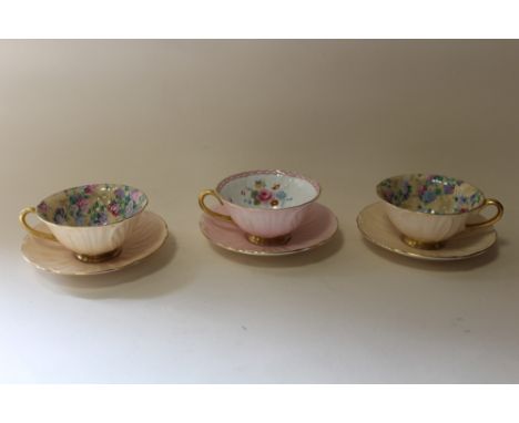 THREE VINTAGE SHELLEY CUPS AND SAUCERS WITH FLORAL INTERIORS, PINK EXAMPLE WITH DAMAGE TO BASE