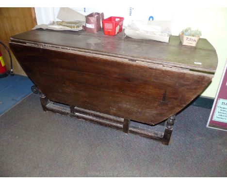 An Oak circa 1800 gate-leg drop-leaf Table of large dimensions, one leaf absent, the other with outer part missing, 62'' x 25