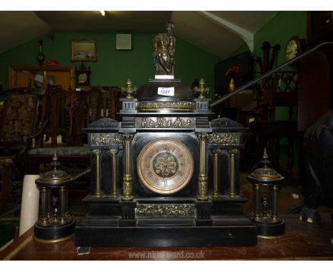 A heavy slate garniture of mantle clock with a pair of temple style side pieces, the clock having Roman numerals and raised c