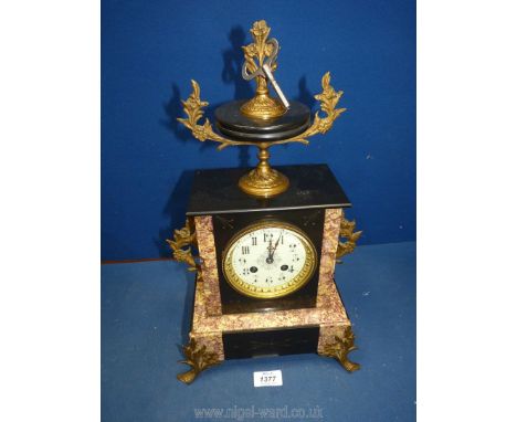 A polished black stone and marble Mantle Clock having an urn pediment and ormolu mounts, the cream face having Arabic numeral