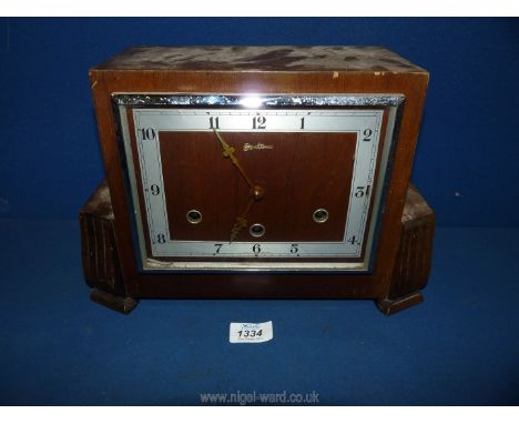 A wooden square mantle clock with Arabic numerals, no key, with pendulum.