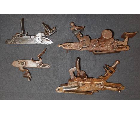 FOUR DETACHED LOCK MECHANISMS, 19TH CENTURY the first for a flintlock pistol (losses); the second for a flintlock gun, the th