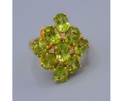 A dress ring set with nine peridot within a pierced setting, ring size O 