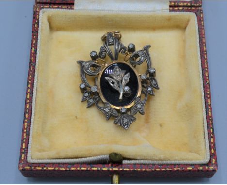 An early 20th Century gold and silver brooch set with diamonds and black enamel, 4cms long 