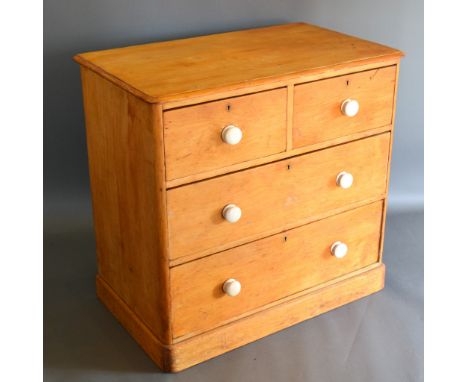 A Pine Chest Of Two Short And Two Long Drawers with ceramic handles raised upon a plinth, 90 cms wide, 53 cms deep, 86 cms hi