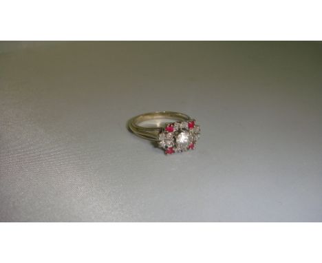 Art Deco unmarked white metal ring set with single diamond surrounded by 12 smaller diamonds and 4 rubies