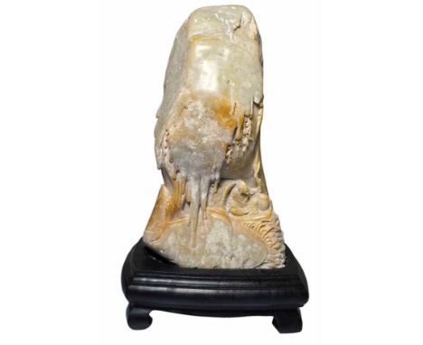 A finely carved scholars stone set on a hardwood stand (possibly Shoushan stone) A fisherman sits in a small shelter beneath 