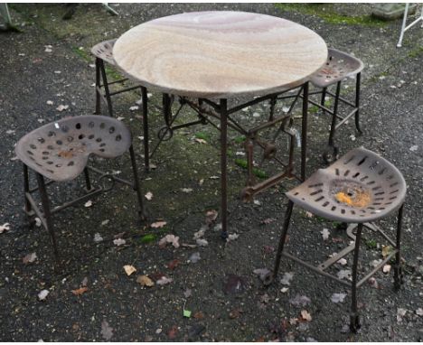 An artisan designed reclaimed agricultural component garden dining set comprising a circular stonecrete top table on reclaime