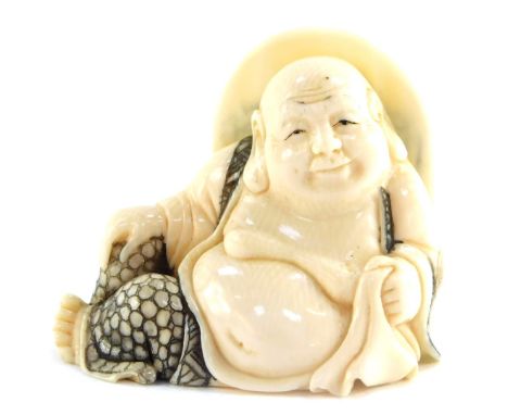 A Japanese late Taisho / early Showa period  marine ivory netsuke of reclining Buddha, signed, 37mm wide. 