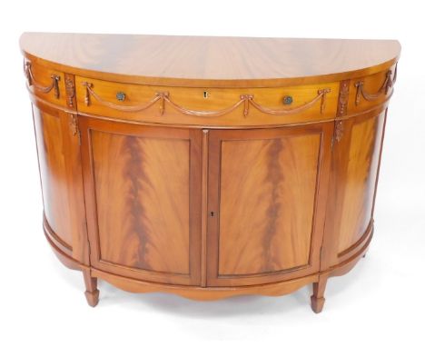 An Adam style reproduction demi lune commode, with a single frieze drawer over a pair of cupboard doors, raised on tapering s