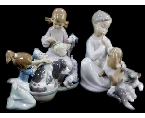 A Lladro porcelain figure modelled as Bashful Bather, boxed, together with Boy With Dog (AF), Honey Lickers, and a cat and mo