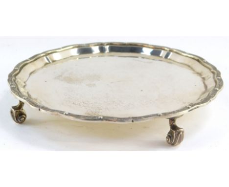 A silver piecrust salver, the gadrooned rim embossed with Celtic beasts, raised on four scroll feet, Edinburgh 1967, 11.49oz.