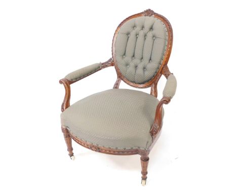 A Victorian mahogany balloon back armchair, with foliate carving, green patterned fabric, button back, arm rests and over stu