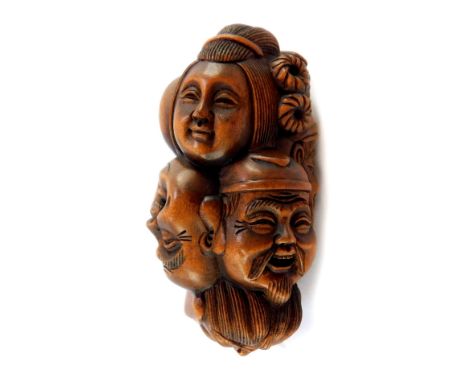 A Japanese late Taisho / early Showa  period wooden netsuke of the heads of the Seven Immortals, signed, 55mm high.