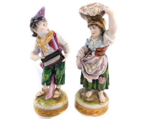 Two Volkstedt porcelain figures, one modelled as a boy playing a hurdy-gurdy, 15cm high (AF), the other as a fisherwoman, 15.