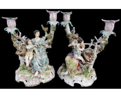 A pair of Dresden twin branch porcelain candelabra, modelled with figures of young ladies and cherubs, 27cm high. (AF)