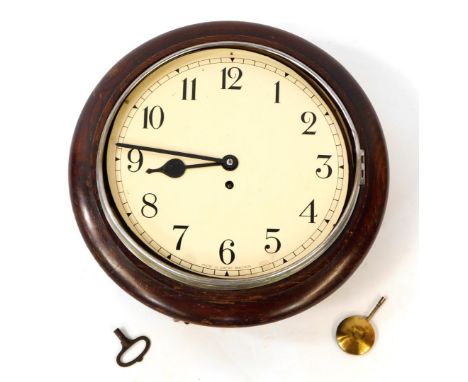 An early 20thC oak cased wall clock, circular dial bearing Arabic numerals, with key, 39.5cm diameter. 