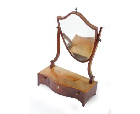 A George III mahogany serpentine dressing table mirror, with cross banded flame top and three drawers with bracket feet, the 