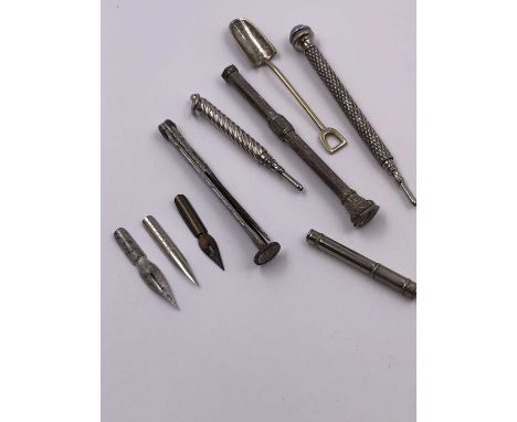 A continental silver propelling pencil, two plated examples, a small salt shovel, pen nibs, etc. 