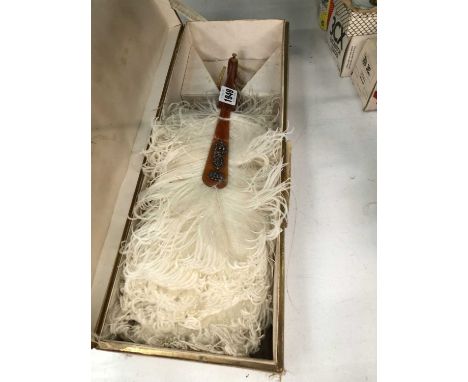 A boxed white ostrich feather fan, the faux tortoiseshell guard stick with a crowned monogram