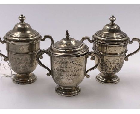 Three hallmarked silver presentation trophy cups. Gross silver weight 385 grams. 