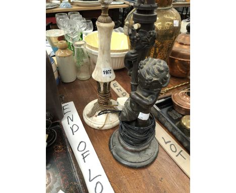 A bronze child holding a torch as a table lamp together with another table lamp