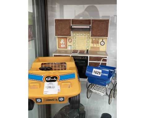 A toy cooker range, a pram and a yellow 'Sindy' car