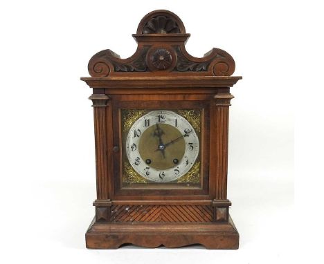 A late 19th century carved walnut cased bracket clock, the brass dial signed Mann, Gloucester, 44cm high