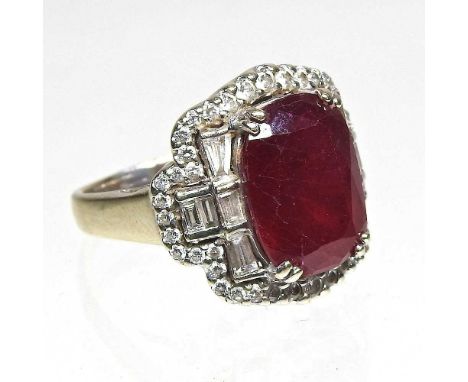 A large 18 carat gold ruby and diamond cluster ring, the central stone approximately 6.0 carats, flanked by eight diamonds, w