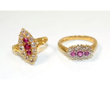 An 18 carat gold ruby and diamond navette ring, three round cut rubies within a border of old cut diamonds, to scroll shoulde