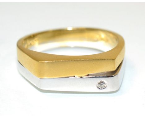 An 18 carat two colour gold diamond ring, an angular bright polished white gold band inset with a single round brilliant cut 