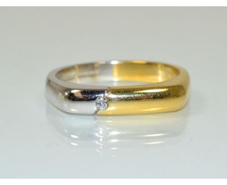An 18 carat two colour gold diamond ring, a part white and part yellow gold angular shank inset with a single round brilliant