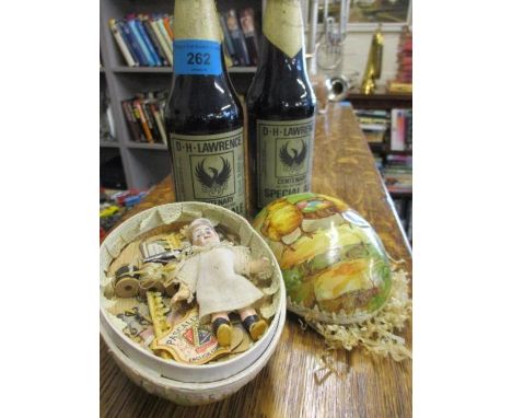 A paper covered Easter egg containing a small bisque doll, two scissors, miniature cotton reels and related item, together wi