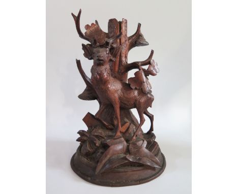 A Black Forest Carved Lamp in the form a a deer standing before an oak tree, 30cm, faults