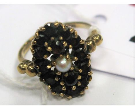 A 9ct Gold Garnet and Pearl Set Cluster Ring, of oval design claw set throughout. 