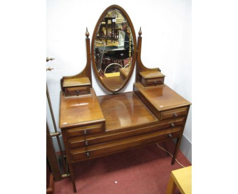 An Edwardian Mahogany Dressing Table, oval bevelled mirror, with finial capped shaped supports and trinket drawers, above two