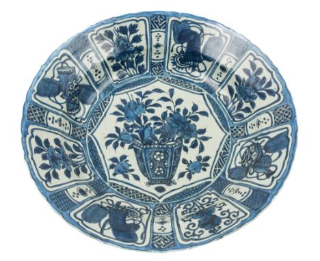 A large Chinese blue and white Kraak charger: painted with a jardiniere of flowers within a central shaped octagonal panel, t