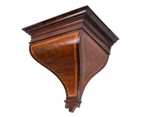 A mid-nineteenth century mahogany clock bracket: the curved tapering base with satinwood crossbanding and scroll moulding to 