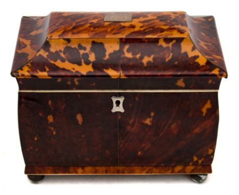 A 19th century blonde tortoiseshell tea caddy: of sarcophagus outline, the shallow domed hinged lid enclosing two lidded comp