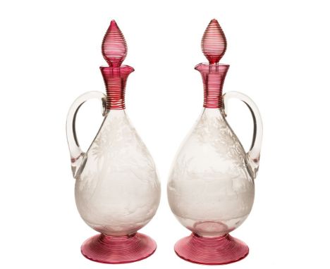 A pair of late 19th century engraved and applied glass claret jugs and stoppers: probably Stevens and Williams, each with thr