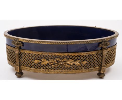 A late 19th century Sevres porcelain and gilt mounted planter: of oval outline, with pierced trellis and baskets of flowering